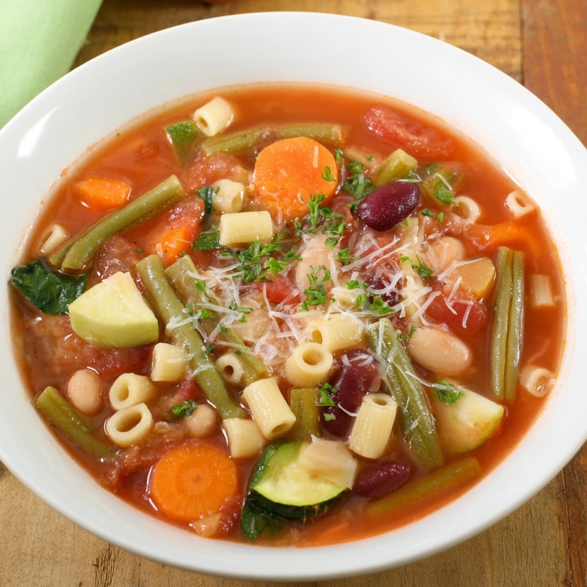 Close-up view: hearty Vegetable Minestrone Soup with grated parmesan, a comforting Italian dinner.