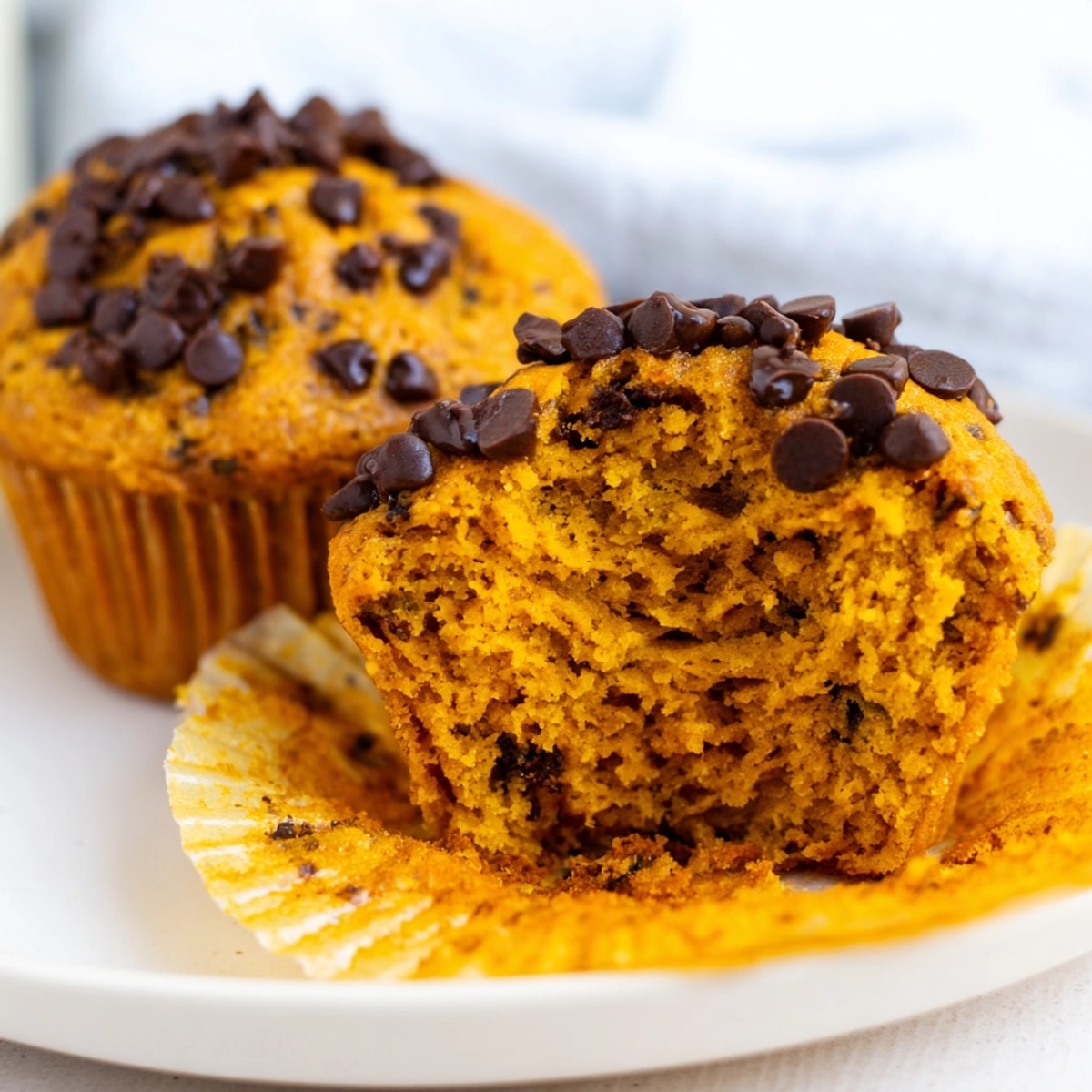 Warm, spiced Gluten-Free Pumpkin Muffins cooling on a wire rack, autumn baking vibes.