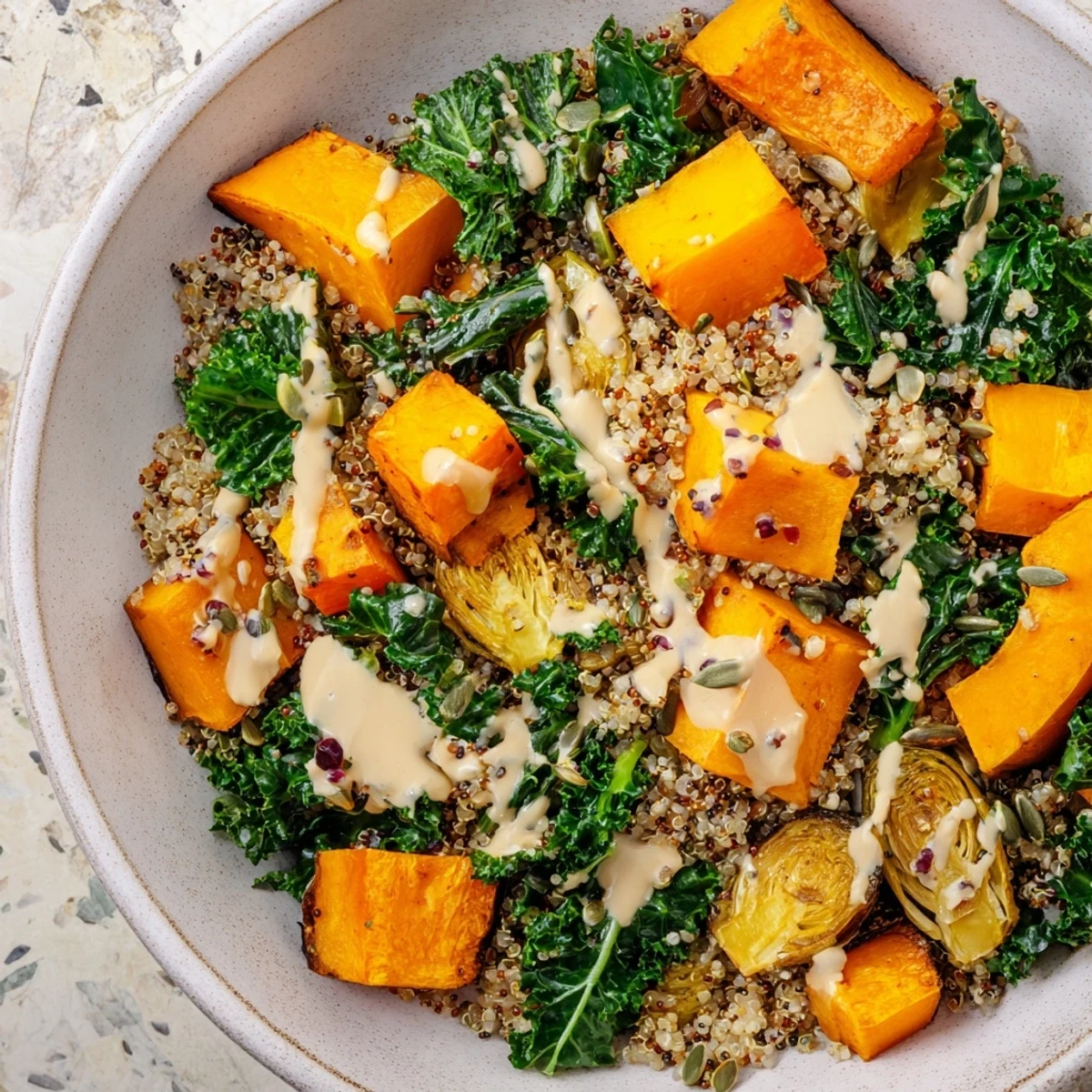 Bright, colorful Winter Harvest Vegan Bowl, showcasing roasted vegetables and a creamy tahini dressing.