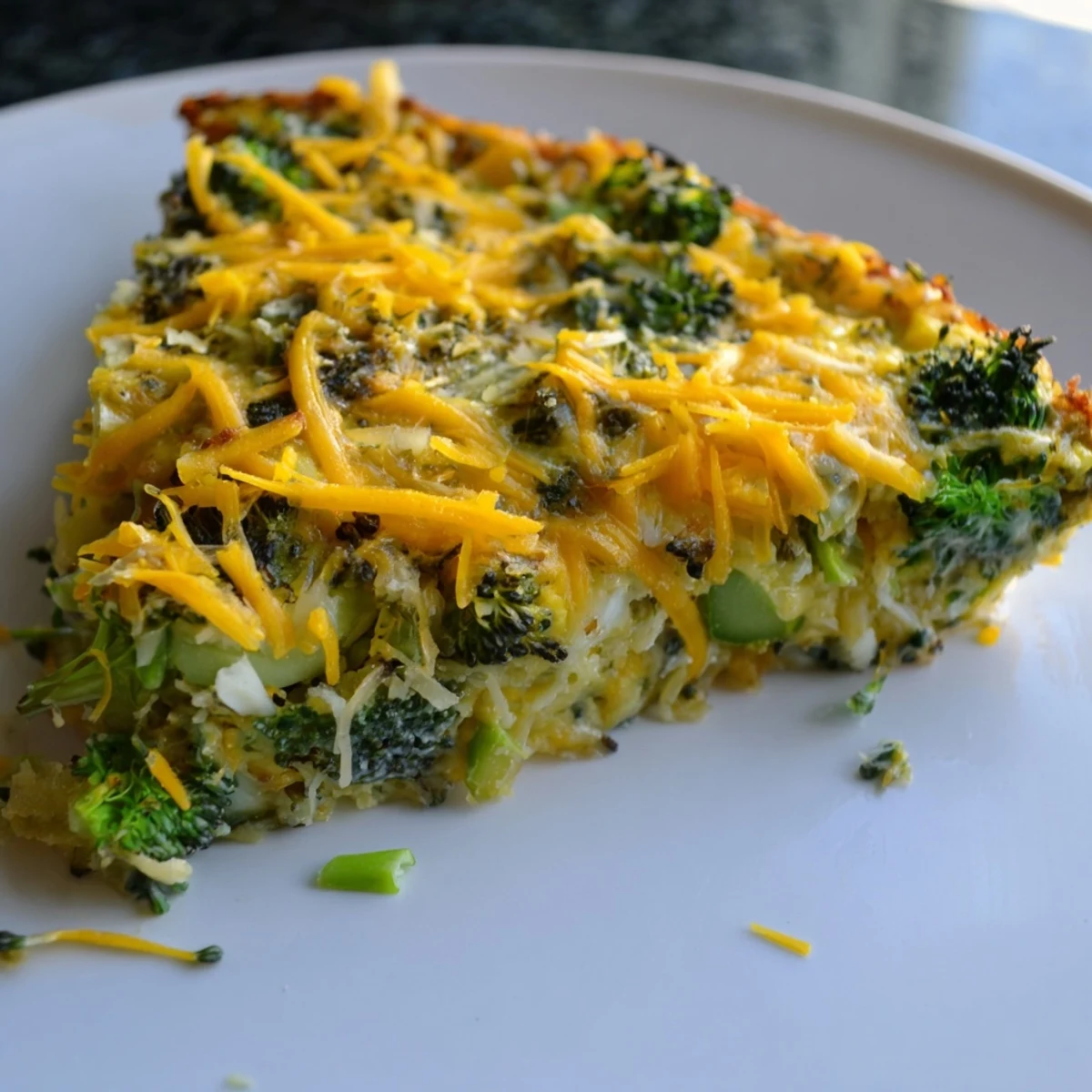 Vibrant green vegetables and melted cheese in a slice of Evergreen Low Carb Bake, ready to serve.