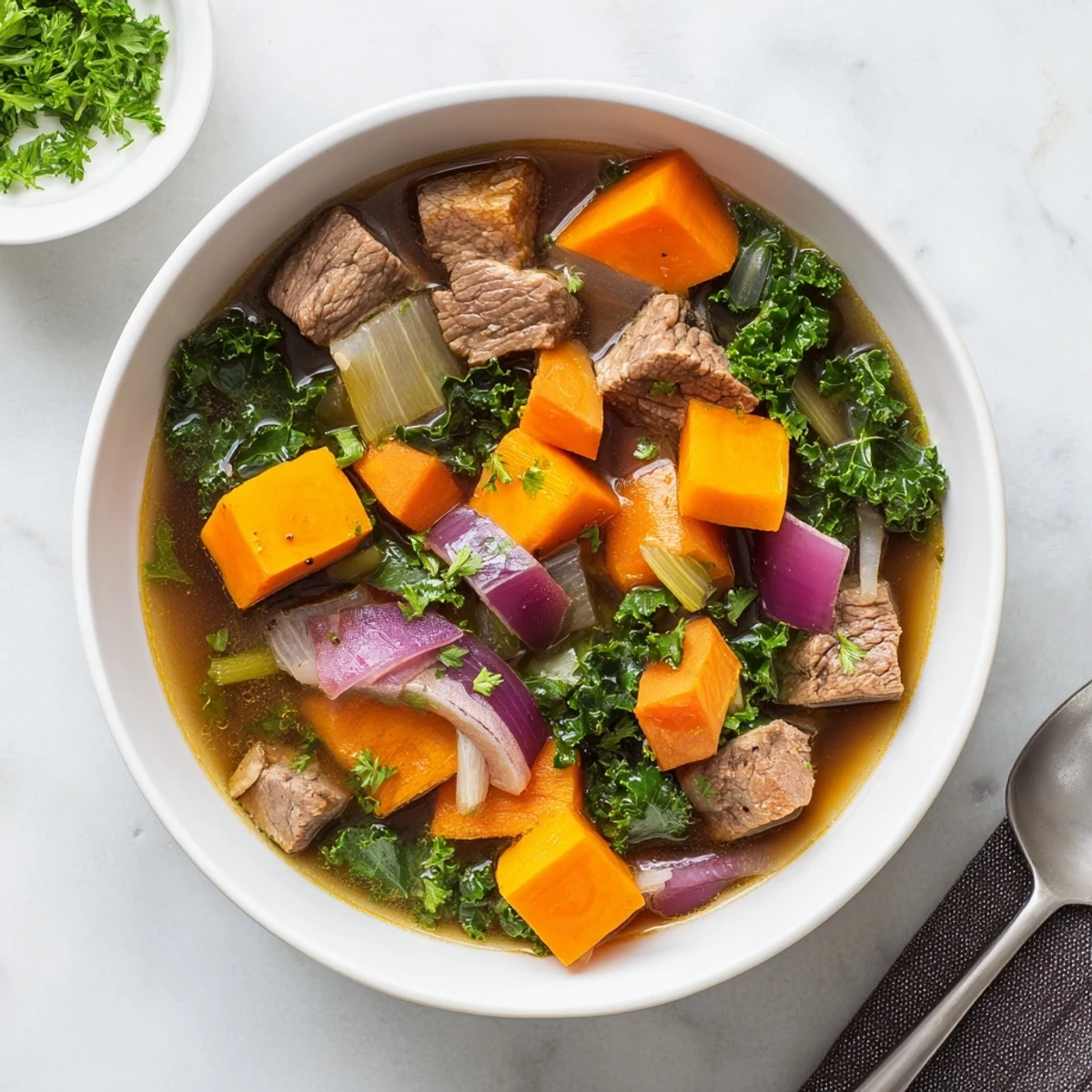 Hearty Seasonal Glow Paleo Stew simmering in a Dutch oven with rich, savory broth and tender beef chunks.