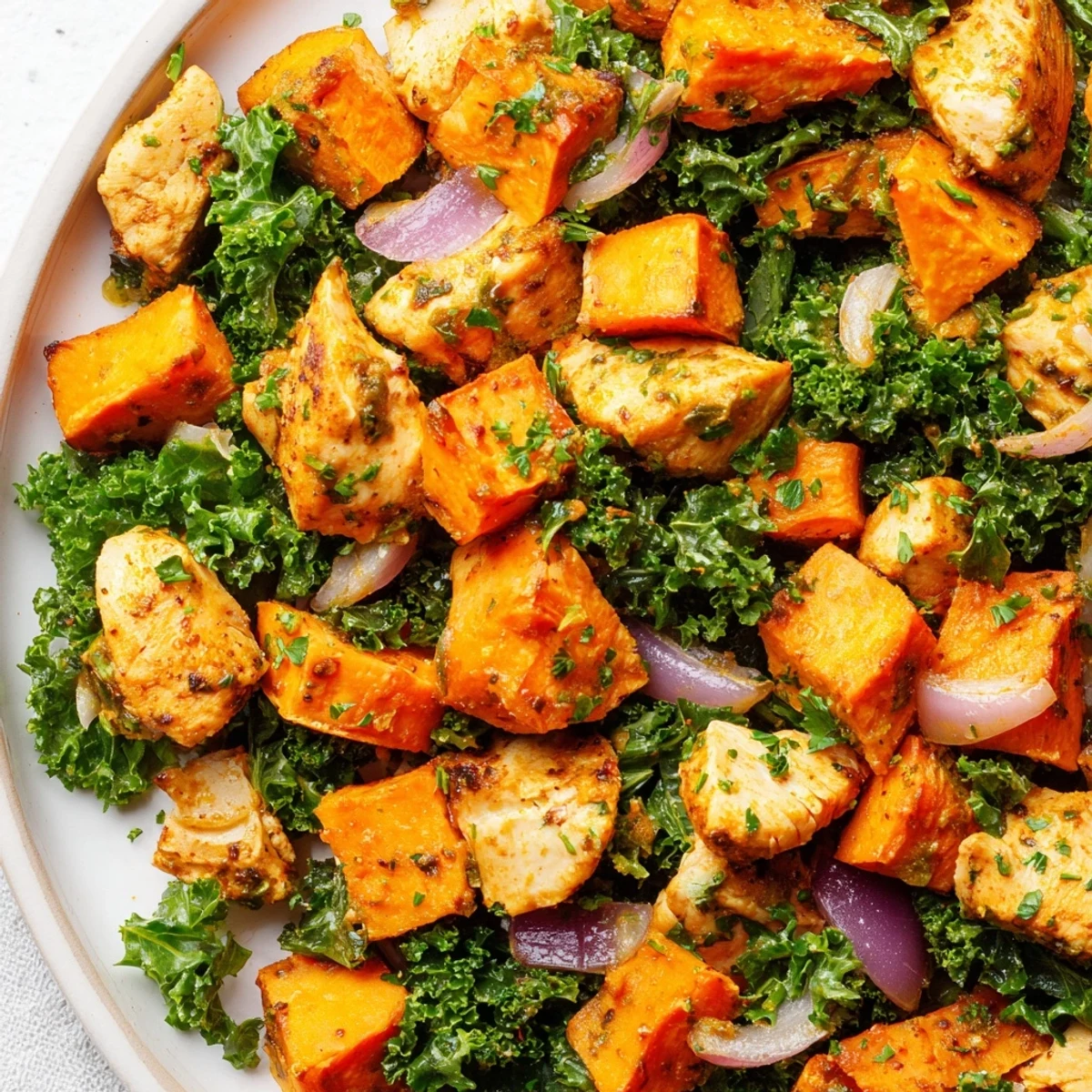 A rustic skillet of Winter Wellness Paleo Bake features tender chicken, caramelized sweet potatoes, and wilted kale.
