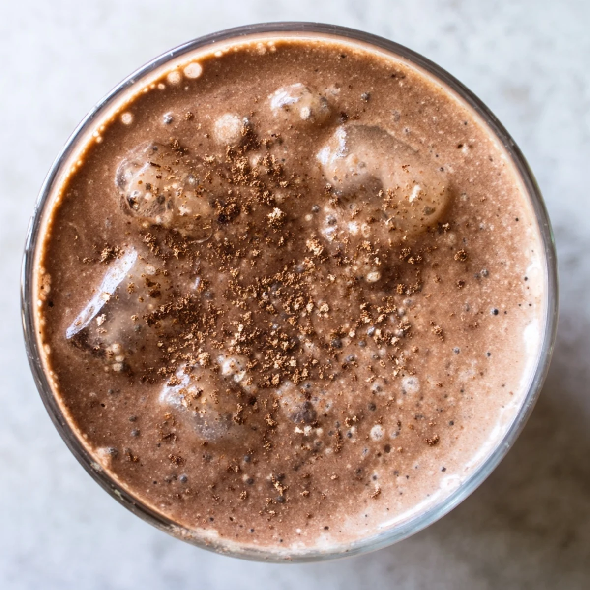 A creamy Snowy Day Keto Smoothie in a glass, topped with cinnamon and cacao nibs, perfect for cozy winter mornings.