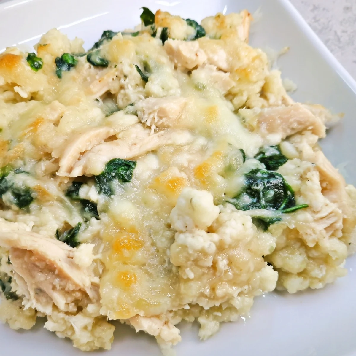 Serving up a slice of the Snowy Day Keto Bake, creamy eggs and spinach blend with savory parmesan for a satisfying low-carb meal.