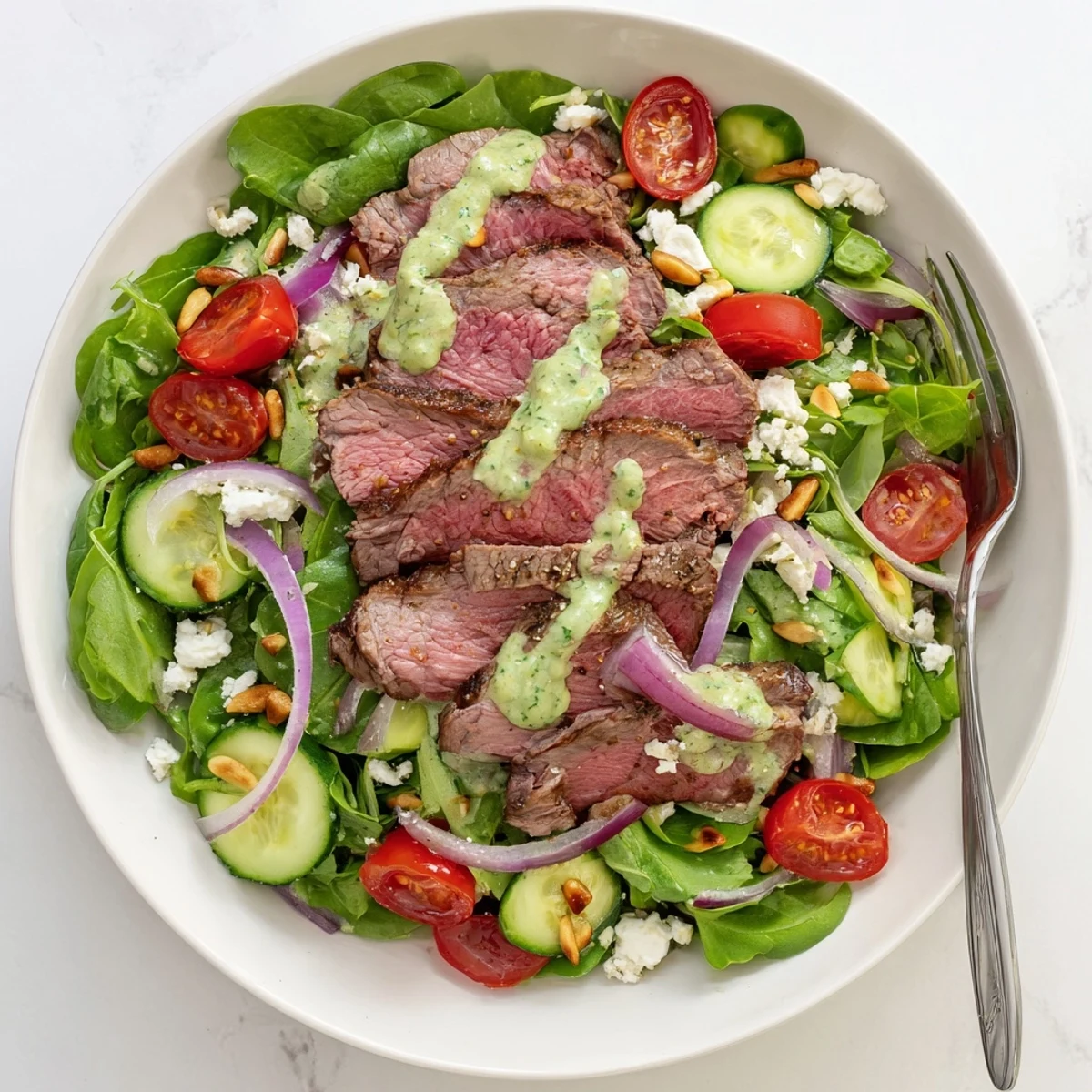 A close-up view of the Garlic Herb Steak Salad With Avocado Lime Dressing highlights tender meat and creamy dressing for a fresh meal.