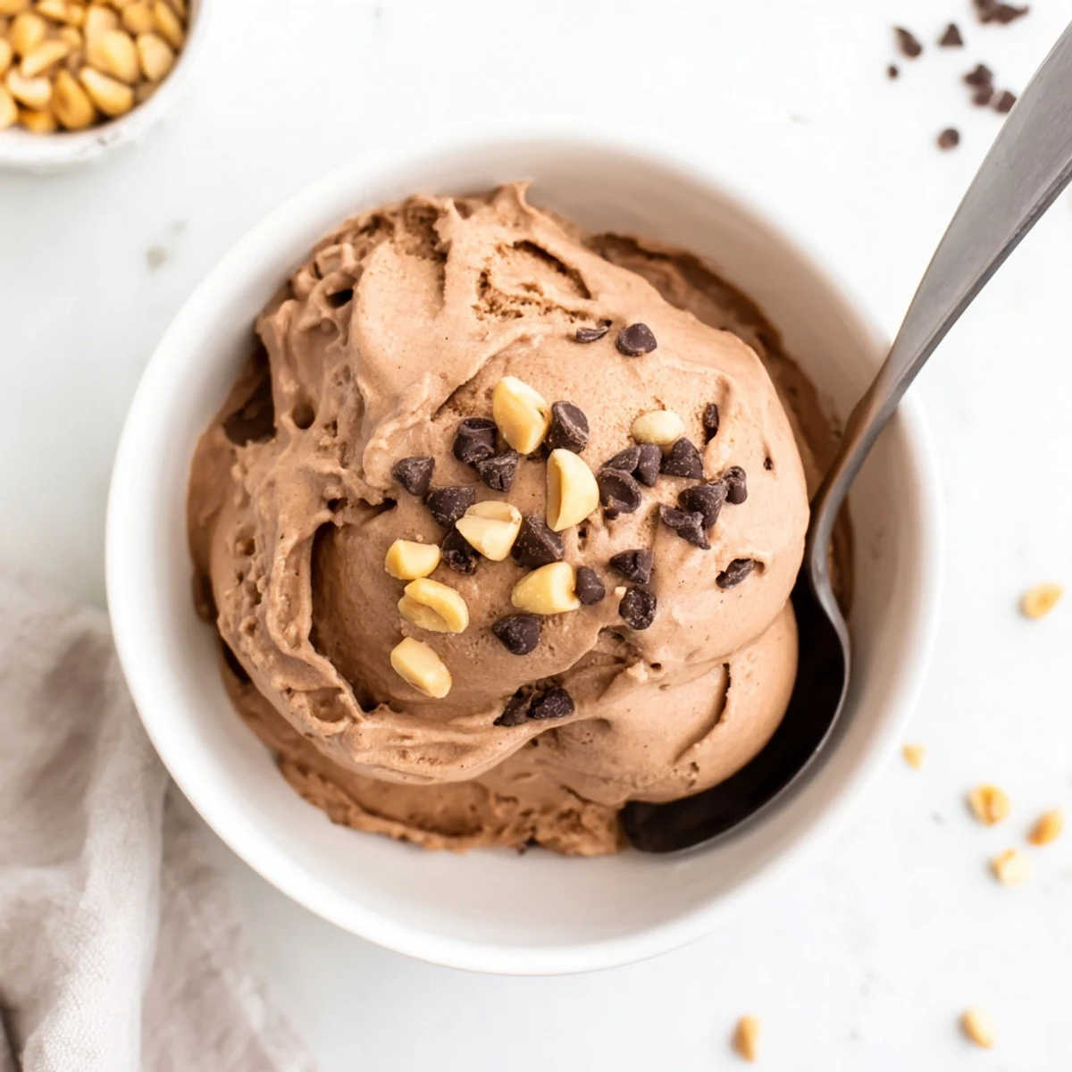 Creamy scoops of Chocolate Peanut Butter Protein Nice Cream topped with chopped peanuts and chocolate chips.