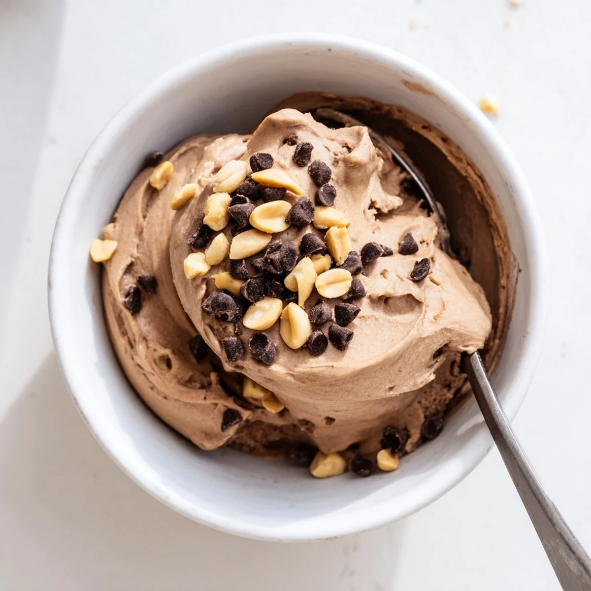 Homemade Chocolate Peanut Butter Protein Nice Cream in a blender ready to serve with a drizzle of peanut butter.