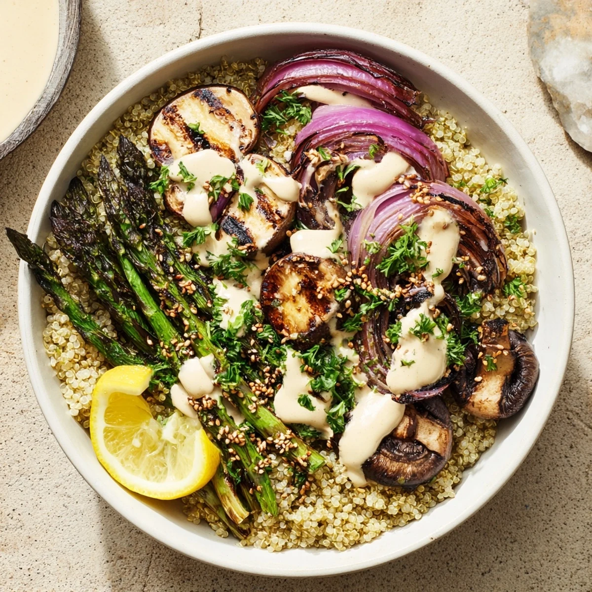 Colorful grilled lemon tahini asparagus and mushroom bowl with charred vegetables over fluffy quinoa