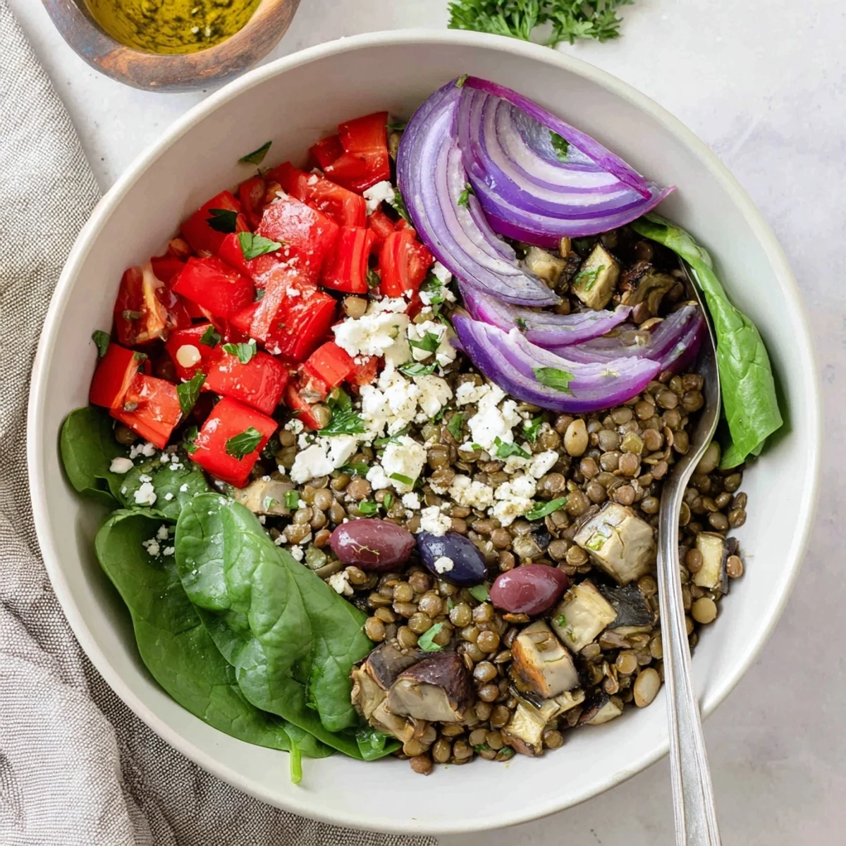 Vibrant Mediterranean lentil and roasted eggplant bowl arranged in a serving dish with Mediterranean toppings