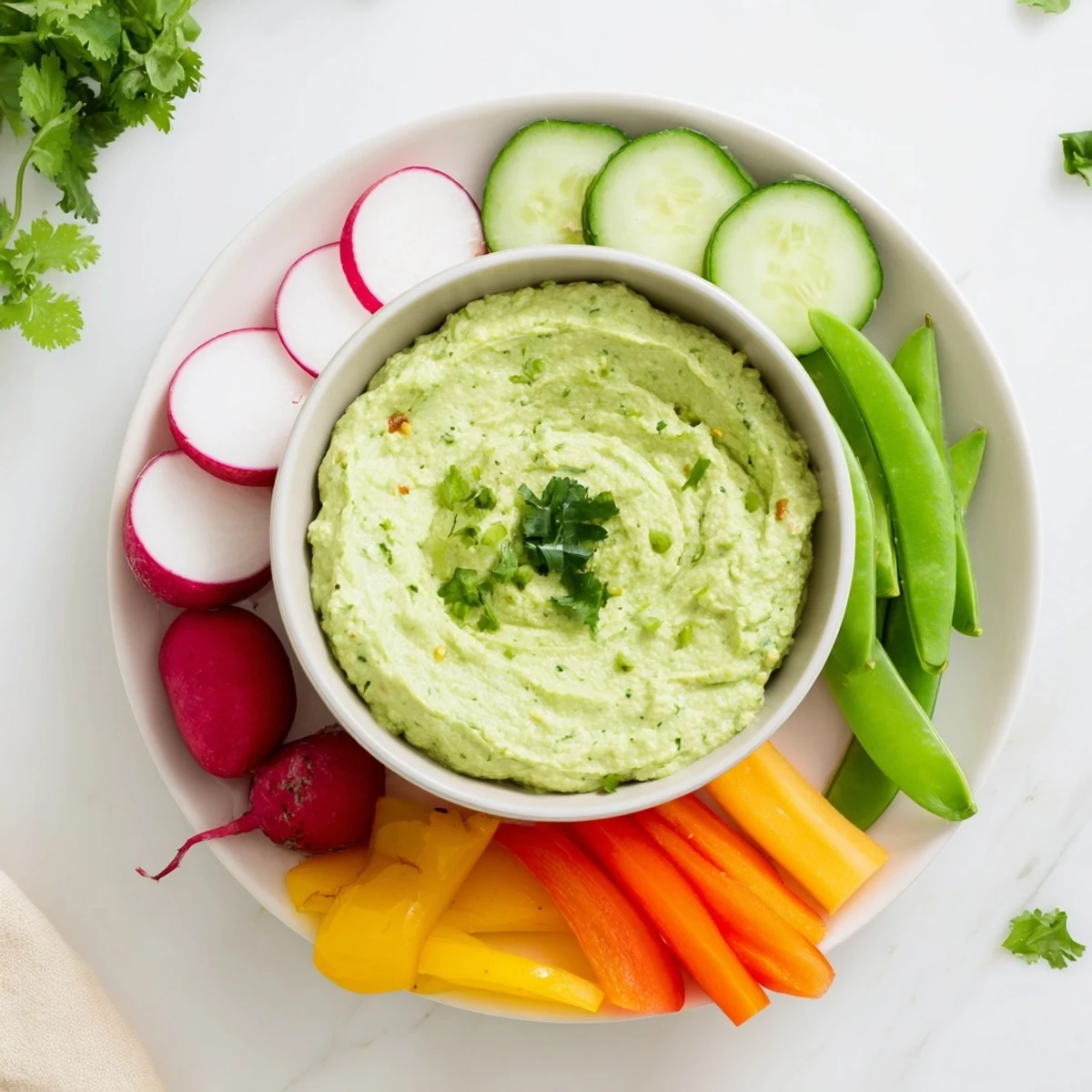 Creamy cottage cheese avocado lime dip served with crisp carrot and cucumber sticks