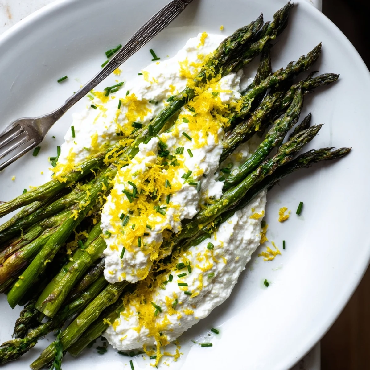 Golden brown asparagus roasted to perfection served with fluffy lemon ricotta whip and fresh chive garnish